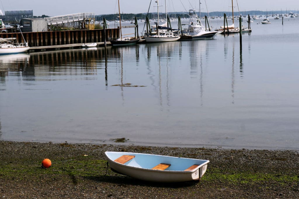 Small boat in the bay with yachts.  The Atlantic ocean seen from Massachusetts.  